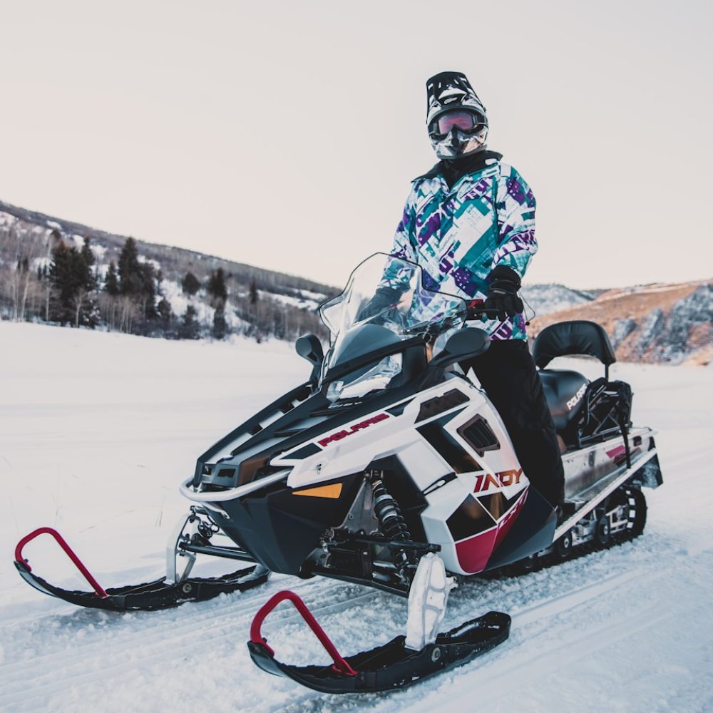 man riding white snowmobile